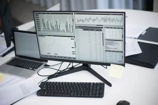 A professional workspace featuring computers and analytical graphs on a monitor, symbolizing modern business environment. Reading email marketing analytics benchmarks without fooling yourself