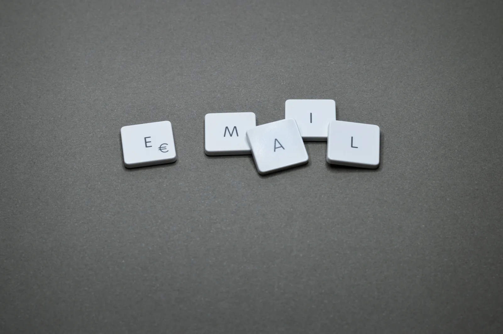Close-up of the word 'email' formed with letter tiles on a gray surface. Email marketing strategy best practices: the discipline behind the results