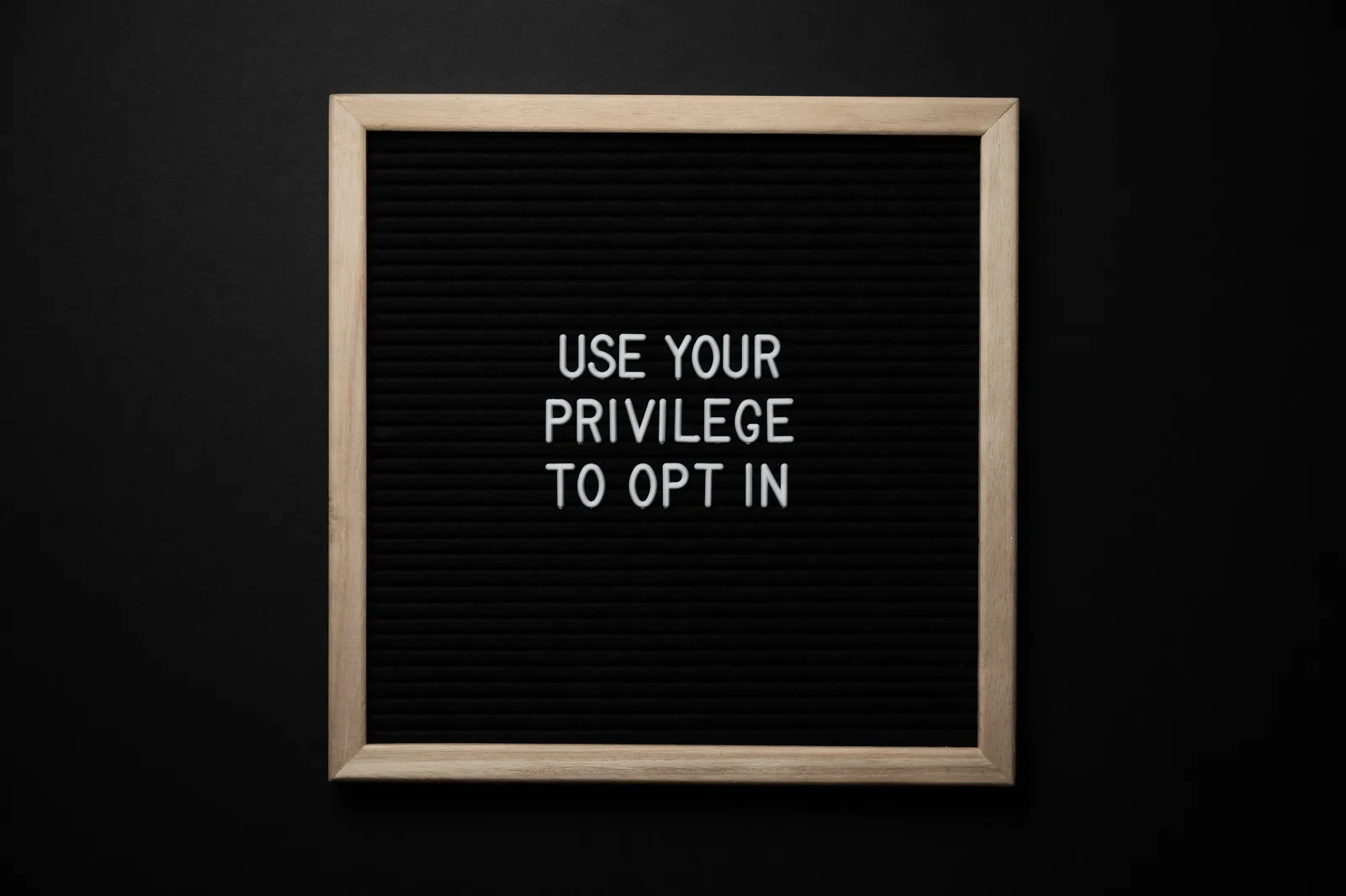 From above composition of contrast blackboard in wooden frame with white USE YOUR PRIVILEGE TO OPT IN title on black background. 9 details of email marketing strategy tools people miss