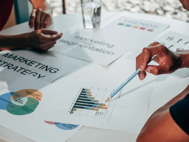 Team working on marketing strategy using data charts and papers in an office meeting. Email segmentation best practices for governance