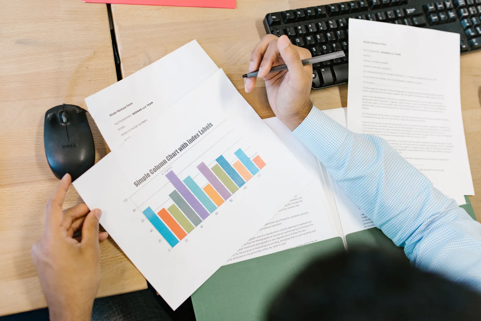 A business analyst reviews a colorful bar chart and documents at a desk, indicating data analysis. Choosing email marketing software without vendor names: an eight step method